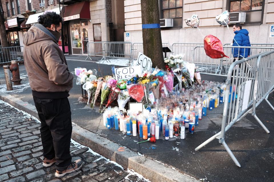 Flowers, candles and balloons form part of a growing memorial outside of the 32nd Police Precinct in Harlem days after a shooing left one officer dead and a second in critical condition on Monday in New York City.