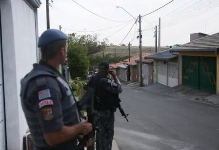 Police officers are seen near a site where an armed gang holds people hostage after they robbed a securities company at the Viracopos airpoart freight terminal, in Campinas
