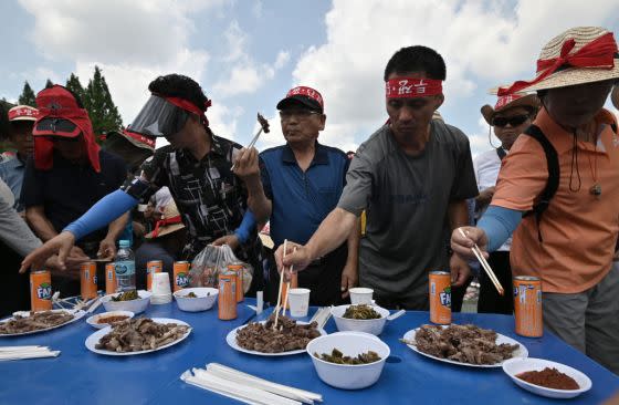 South Korean dog farmers eat dog meat during a counter-rally against animal rights activists, in front of the National Assembly in Seoul on July 12, 2019.<span class="copyright">Jung Yeon-je—AFP/Getty Images</span>