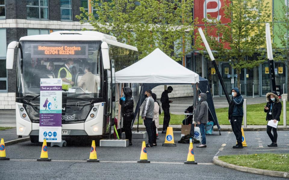 People queue for vaccinations from a 'Covid bus' in Bolton, where the variant is thought to have driven a doubling of infections over the past seven days - Paul Cooper