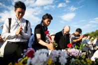 <p>Visitors lays flowers and pray for the atomic bomb victims in front of the cenotaph at the Hiroshima Peace Memorial Park in Hiroshima, western Japan, Sunday, Aug. 6, 2017. (Photo: Richard Atrero de Guzman/NurPhoto via Getty Images) </p>