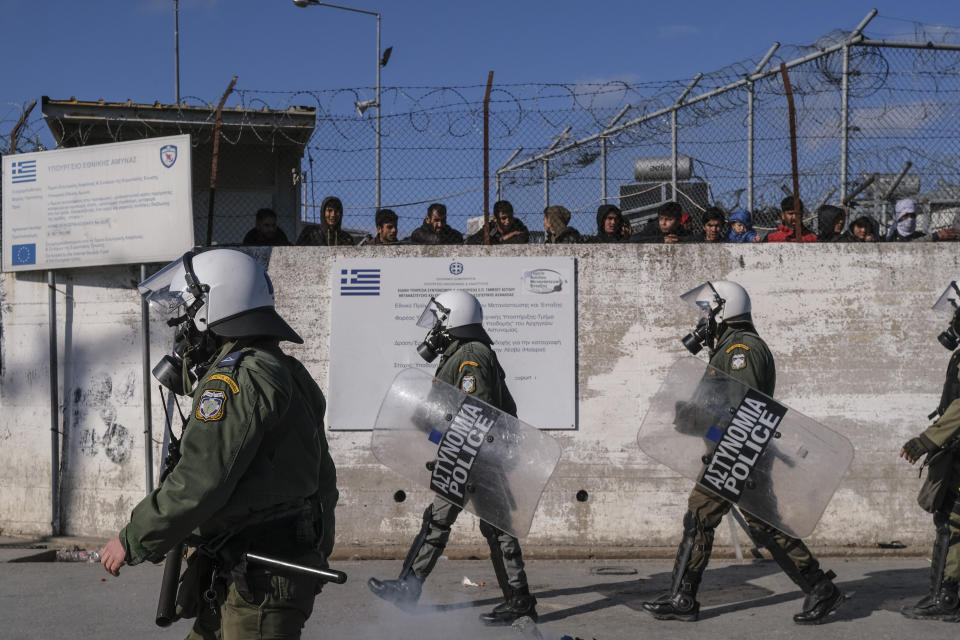 Greek Riot Police walk outside Moria camp, as refugees and migrants protest following the stabbing death of an 20-year-old man from Yemen in the Greek island of Lesbos, Friday, Jan, 17, 2020. Authorities arrested a 27-year-old Afghan migrant in connection with the incident. Overcrowding at Moria has steadily worsened over the past year as the number of arrivals of migrants and refugees using clandestine routes from Turkey to the Greek islands remains high _ and totaled nearly 60,000 in 2019. (AP Photo/Aggelos Barai)