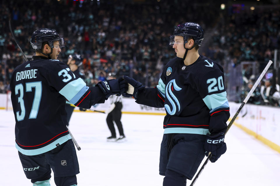 Seattle Kraken center Yanni Gourde (37) fist-bumps right wing Eeli Tolvanen after Tolvanen scored against the San Jose Sharks during the third period of an NHL hockey game Wednesday, Nov. 22, 2023, in Seattle. (AP Photo/Maddy Grassy)