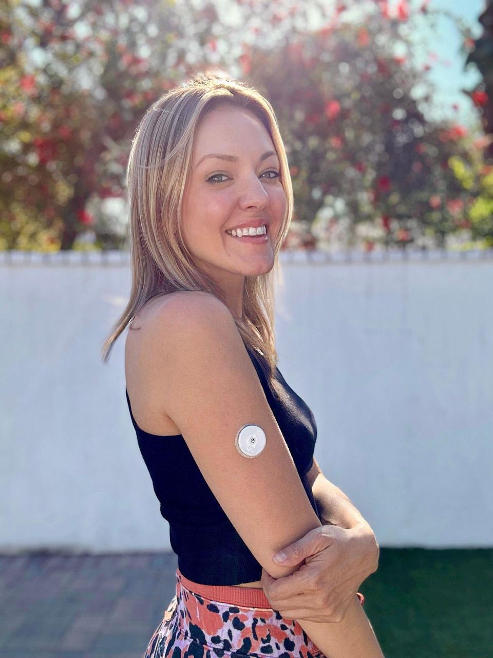 Brittney Bouchard, a wellness coach, poses with her CGM