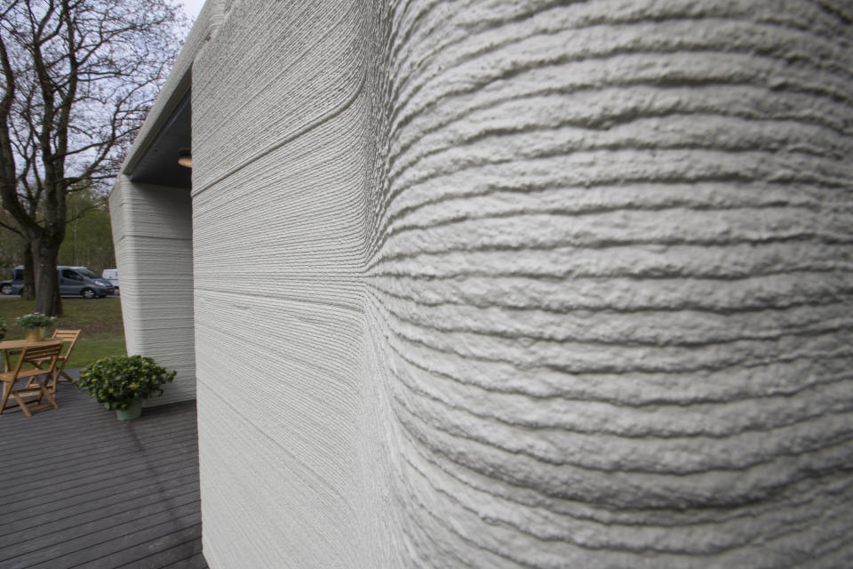 Exterior view showing the printer layers of the 3D-printed 94-square meters (1,011-square feet) two-bedroom bungalow resembling a boulder with windows in Eindhoven, Netherlands, Friday, April 30, 2021. The fluid, curving lines of its gray walls look natural. But they are actually at the cutting edge of housing construction in the Netherlands and around the world. They were 3D printed at a nearby factory. (AP Photo/Peter Dejong)