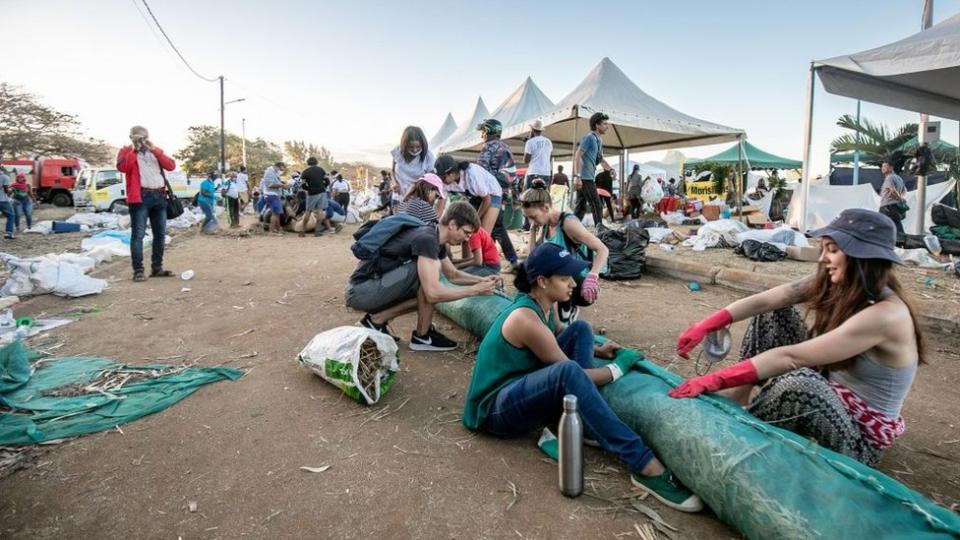 Voluntarios arman cilindros flotantes para atrapar el petróleo derramado en Mauricio