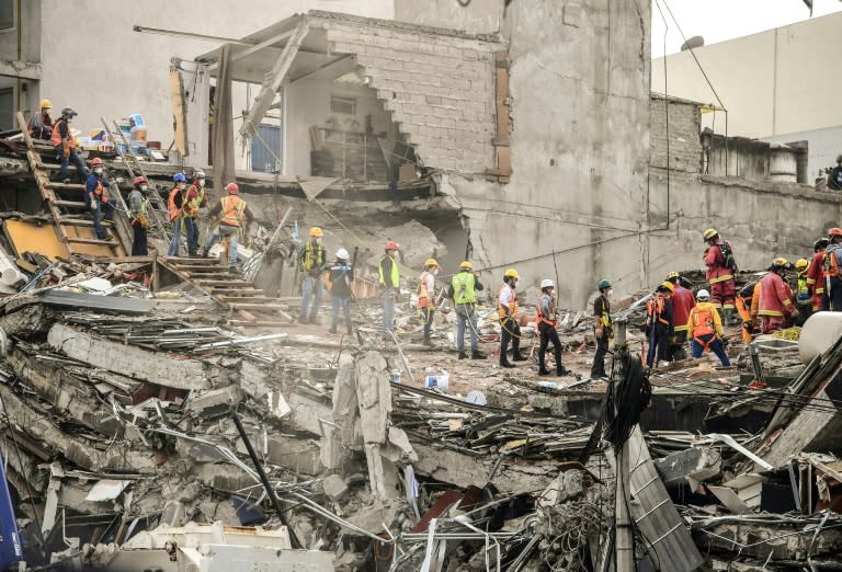 Volunteers help as rescuers search for victims in a Mexico City building, toppled by a 7.1 magnitude quake that struck central Mexico on September 19, 2017