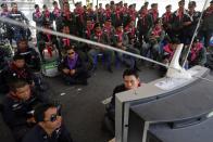 Policemen watch the news as anti-government protesters enter their compound of metropolitan police headquarters, the site of fierce clashes over the last few days, in Bangkok December 3, 2013. Thailand's government ordered police to stand down and allow protesters into state buildings on Tuesday, removing a flashpoint for clashes and effectively bringing an end to days of violence in Bangkok in which five people have died. REUTERS/Damir Sagolj (THAILAND - Tags: CIVIL UNREST POLITICS CRIME LAW)