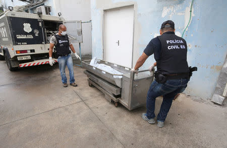 Policemen carry a body at the Institute of Forensic Science in Vitoria, Espirito Santo, Brazil, February 9, 2017. REUTERS/Paulo Whitaker