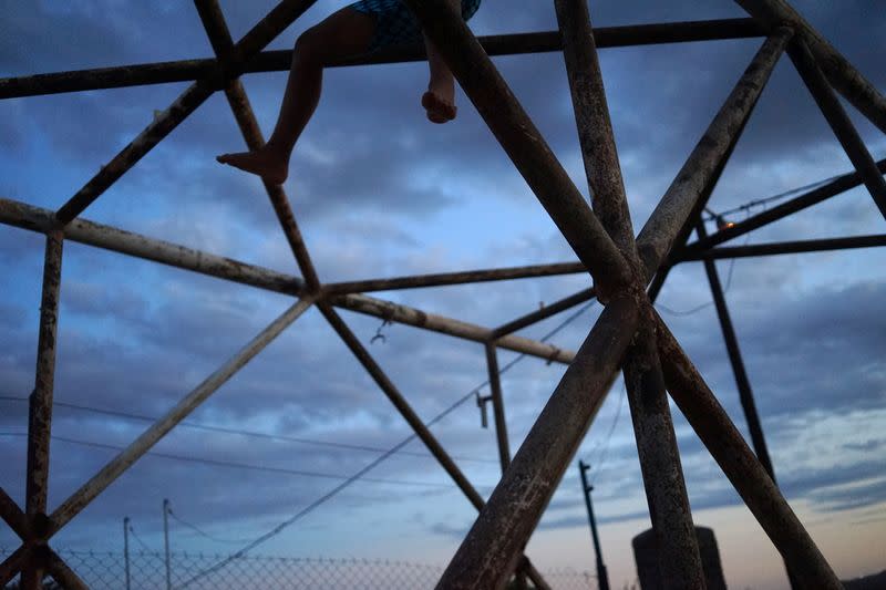 A boy plays on an old scaffold outside his home, in Anelo