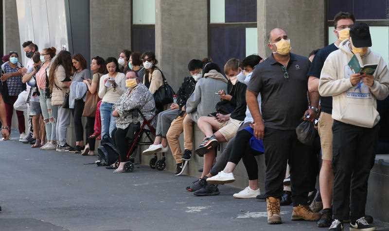 People line up outside the Royal Melbourne Hospital for coronavirus testing in Melbourne.