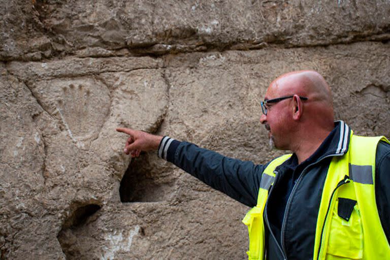 Zubair Adawi, director de excavación de la Autoridad de Antigüedades de Israel, señala una huella de mano tallada descubierta en un antiguo muro de foso alrededor de la Ciudad Vieja de Jerusalén.