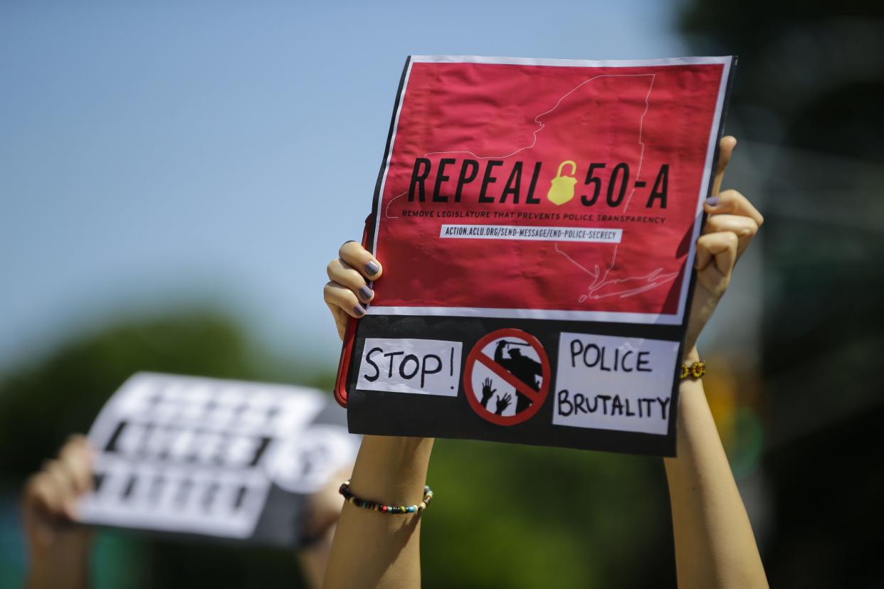 A protester holds a sign outside Queens County Criminal Court i June 2020, calling for the repeal of section 50-a, a law prohibiting the public release of police officer disciplinary records. 