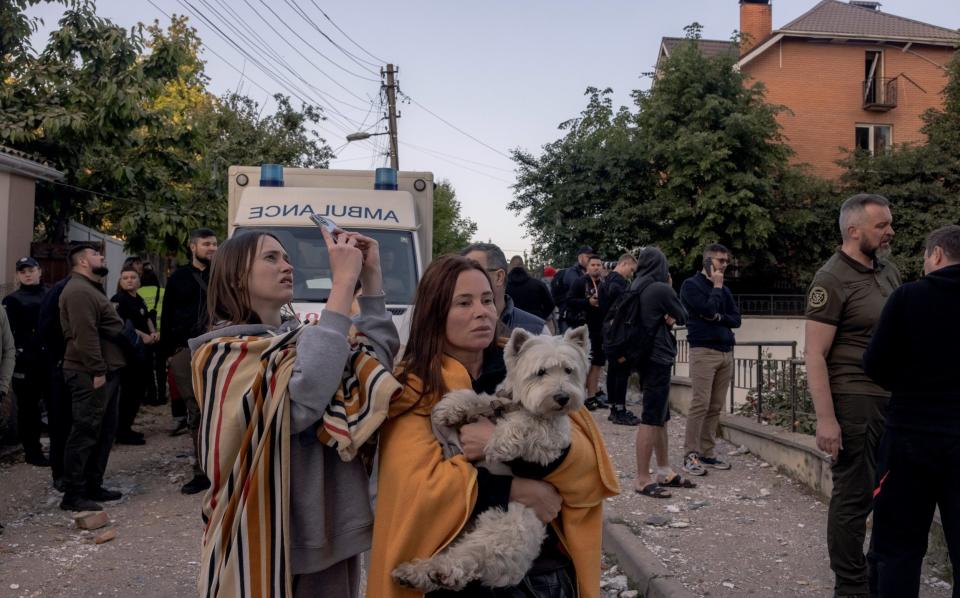 People gather outside a residential building damaged during Russian drone attacks in Kyiv - Roman Pilipey/Getty Images Europe