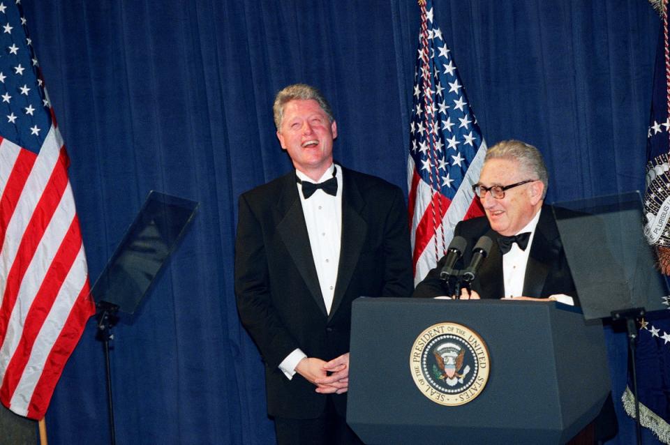 President Bill Clinton, left, and former Secretary of State Henry Kissinger laugh at a national policy conference, March 1, 1995 (AP)