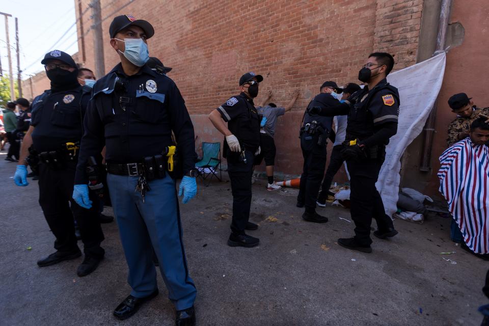 El Paso police patrol an alley where migrants are staying next to Sacred Heart Church on April 29, 2023, in Downtown El Paso.