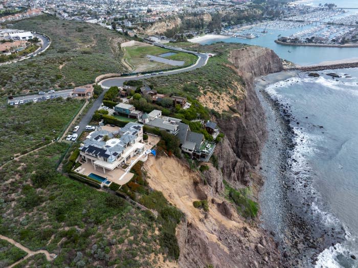 Aerial view of coastal houses on cliffside near a marina