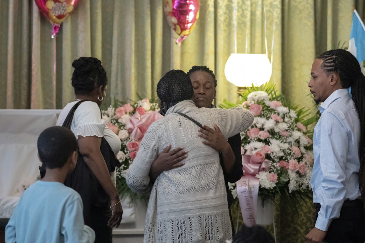 Mabel Alvarez Benedicks, mother of Anadith Danay Reyes Alvarez, center, greets a guest during the wake at R.G. Ortiz Funeral Home on Friday, June 16, 2023, in New York. Dozens of people are remembering the 8-year-old girl who died in Border Patrol custody. (AP Photo/Jeenah Moon)