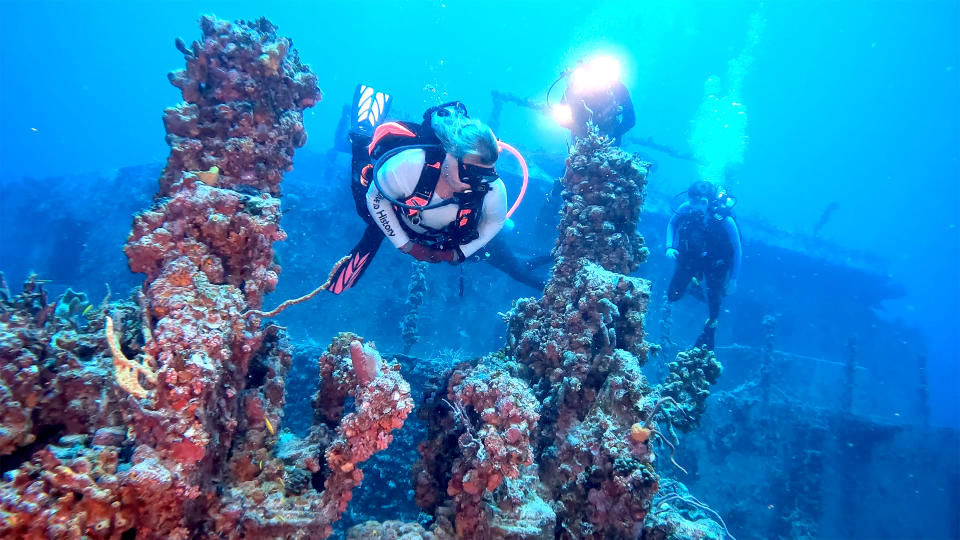 In this Sunday, May 15, 2022, photo provided by the Florida Keys News Bureau, Lisa Mongelia swims between gun turrets of the retired Naval Landing Ship Dock Spiegel Grove, sunk 20 years earlier, six miles off Key Largo, Fla., to become an artificial reef. The vessel's storied past is to be celebrated May 17, 2022, the 20th anniversary of the sinking, with an event at a local cultural center that features key individuals reminiscing about the project. (Frazier Nivens/Florida Keys News Bureau via AP)