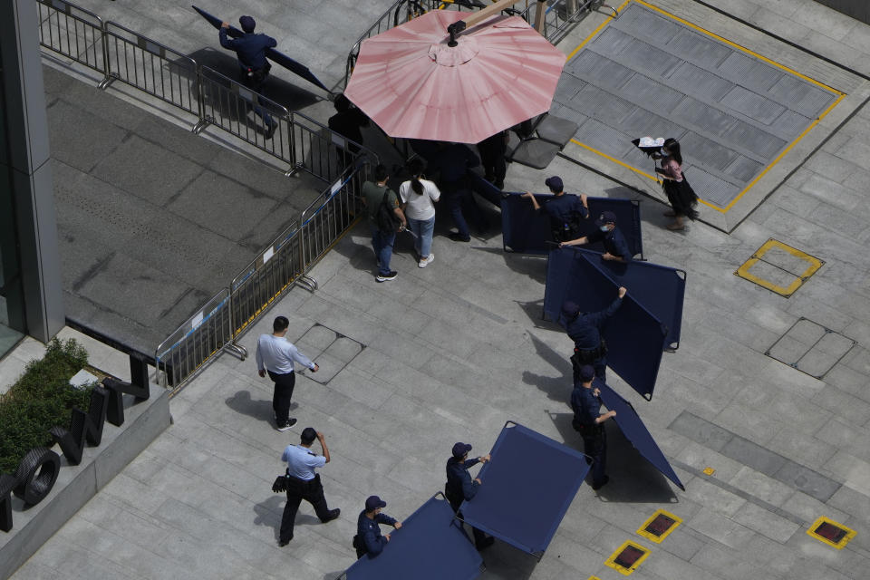 Security guards move barriers intended for us to block off protesters outside the Evergrande headquarters in Shenzhen, China, Friday, Sept. 24, 2021. Things appeared quiet at the headquarters of the heavily indebted Chinese real estate developer Evergrande, one day after the day it had promised to pay interest due to bondholders in China. (AP Photo/Ng Han Guan)