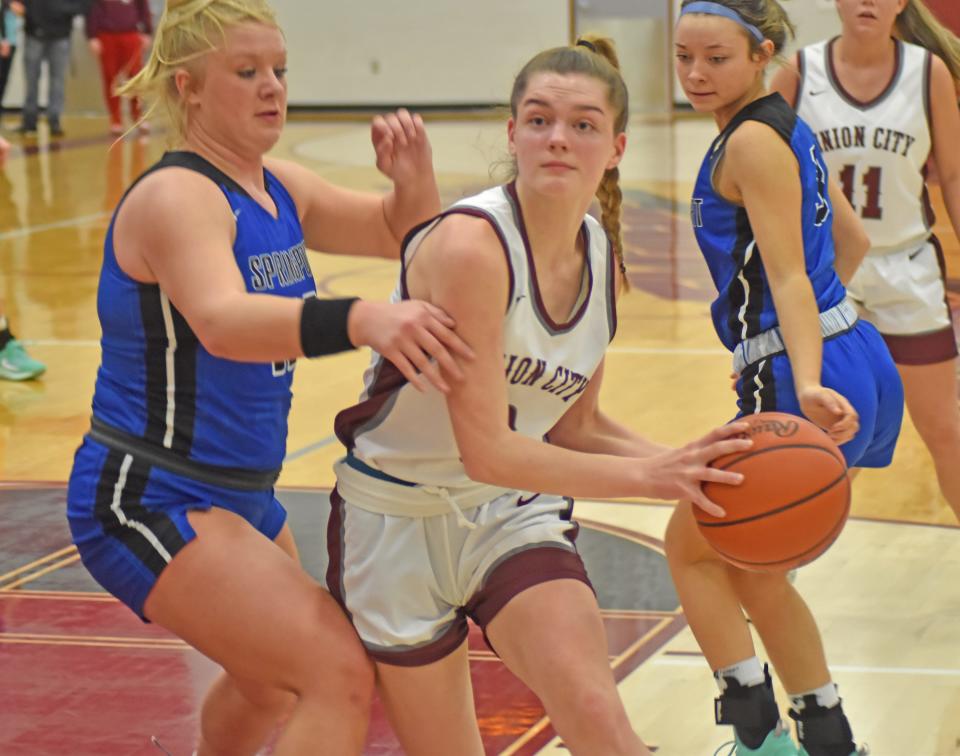 Union City's Makenzie Hale drives to the bucket looking for two while the Springport defense closes in Thursday night