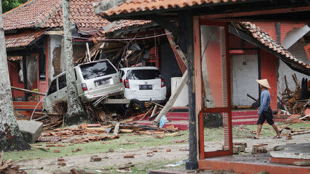 A resident walks past a collapsed guesthouse after a tsunami hit the area at Carita beach in Pandeglang, Banten province, Indonesia, December 23, 2018. REUTERS/Stringer NO RESALES. NO ARCHIVES.