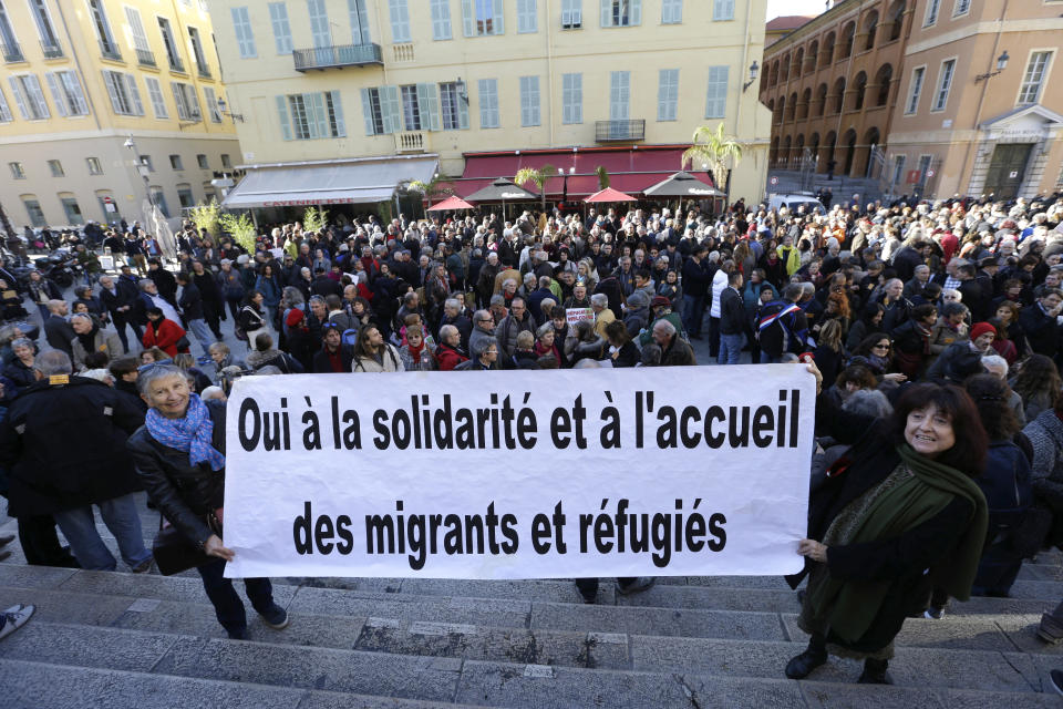 This Jan. 4, 2017 photo shows a crowd supporting Cedric Herrou, a French activist farmer accused of helping African migrants to cross the border from Italy, in Nice, southern France. The banner reads "Yes to solidarity and Welcome migrants and refugees". A French appeals court is expected to hand down a verdict Thursday afternoon in the case of a mountain guide who was convicted for helping migrants enter the country illegally.(AP Photo/Claude Paris, File)