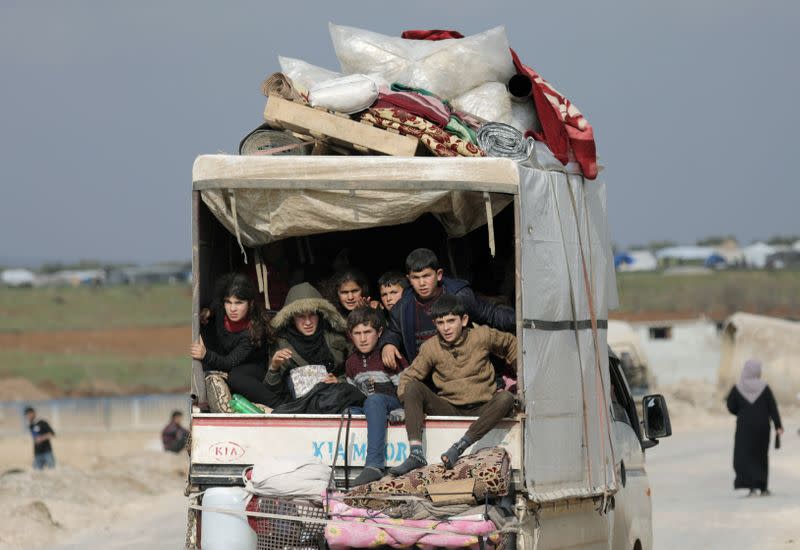 FILE PHOTO: Internally displaced children ride in a pick up truck with their belongings in Afrin