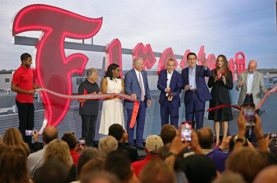 Local officials join Bridgestone Americas President and CEO Paolo Ferrari, center, and other company leaders on stage for a ribbon cutting ceremony at the Bridgestone Advanced Tire Production Center in Akron on Wednesday.