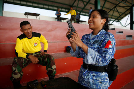 A military trainer helps a participant of the Bela Negara - "defend the nation" - program with weapons familiarization at a training center in Rumpin, Bogor, West Java, Indonesia. REUTERS/Darren Whiteside