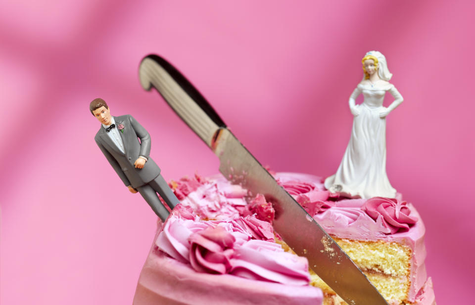 knife cutting between bride and groom figurines, relationship breakup