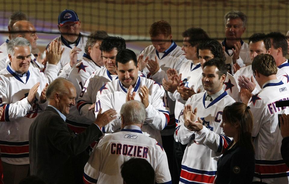 Five decades of Rochester Americans alumni show respects to former coach Joe Crozier, bottom center, as he was announced as the next inductee into the  American Hockey League Hall of Fame, during pregame ceremonies prior to the Amerks home opener between the Wilkes-Barre/Scranton Penguins on Oct. 13, 2011.