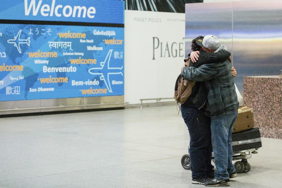 Abdullah Alghazali, right, hugs his 13-year-old son Ali Abdullah Alghazali after the Yemeni boy stepped out of an arrival entrance at John F. Kennedy International Airport in New York, Sunday, Feb. 5, 2017. Travelers from the seven predominantly Muslim countries affected by President Donald Trump's ban enjoyed tearful reunions with family members in the U.S. on Sunday after a federal judge swept the restrictions aside. (AP Photo/Alexander F. Yuan)