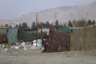 An internally displaced girl peers through the curtain of her temporary home in the city of Kabul, Afghanistan, Monday, Jan. 18, 2021. Half of war-ravaged Afghanistan’s population is at risk of not having enough food to eat, including around 10 million children, Save the Children, a humanitarian organization said Tuesday. The group called for $3 billion in donations to pay for assistance in 2021. (AP Photo/Rahmat Gul)