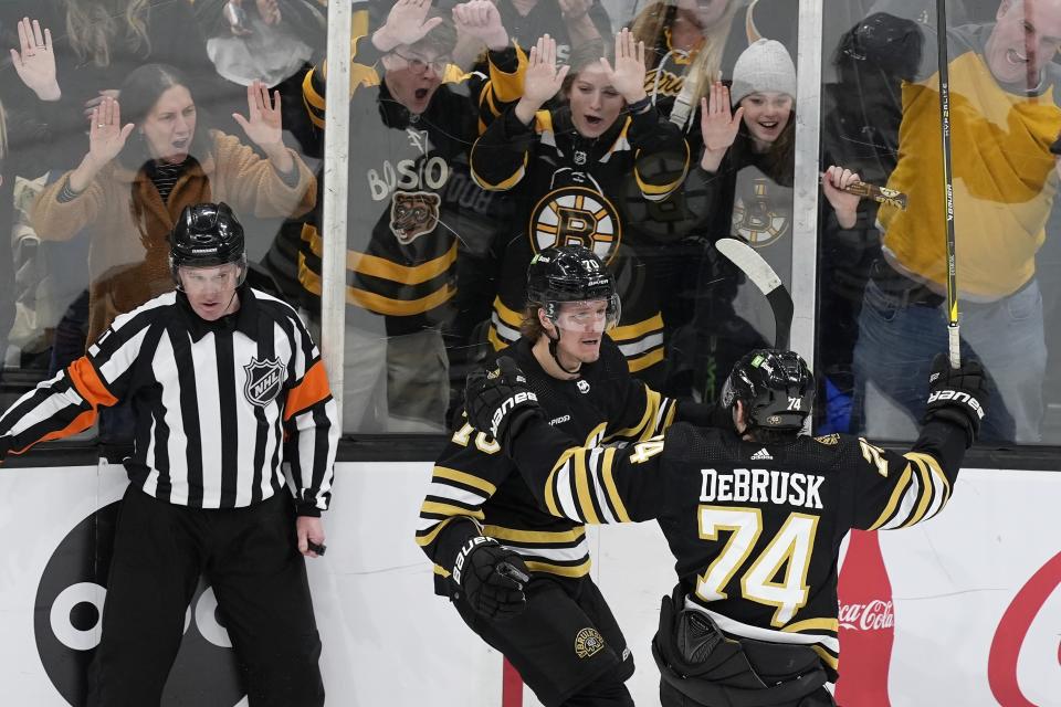 Boston Bruins' Jesper Boqvist (70) celebrates with Jake DeBrusk (74) after scoring in overtime of an NHL hockey game against the Florida Panthers, Saturday, April 6, 2024, in Boston. (AP Photo/Michael Dwyer)