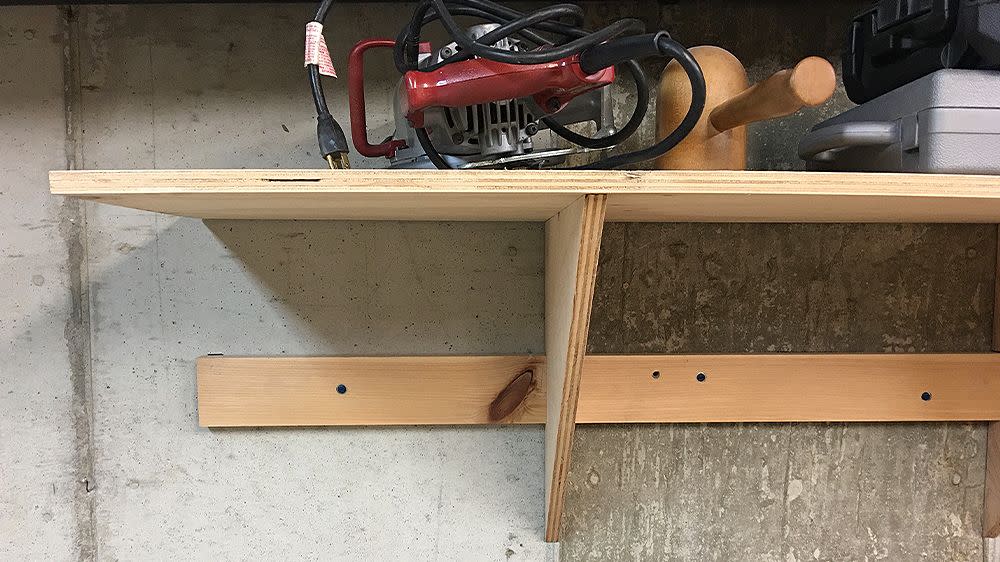 a wooden shop shelf holding some equipment