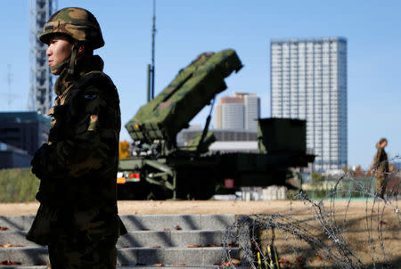 FILE PHOTO - Members of the Japan Self-Defence Forces stand guard near Patriot Advanced Capability-3 (PAC-3) land-to-air missiles, deployed at the Defense Ministry in Tokyo December 7, 2012. REUTERS/Issei Kato/File Photo