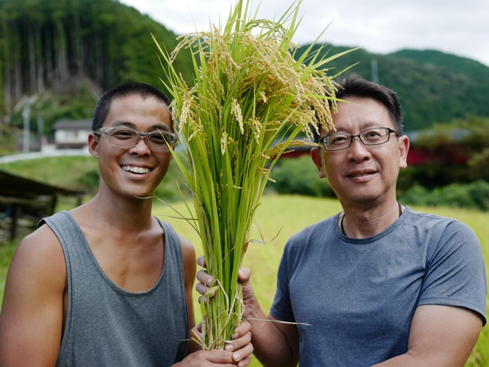 two men holding plants together