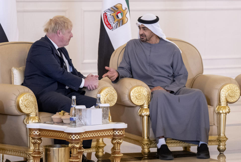 This photo made available by Ministry of Presidential Affairs shows, British Prime Minister Boris Johnson, left, offers his condolences to Sheikh Mohammed bin Zayed Al Nahyan, President of the UAE and Ruler of Abu Dhabi, on the passing of Sheikh Khalifa bin Zayed Al Nahyan, late President of the UAE, in Abu Dhabi, UAE, Sunday, May 15, 2022. (Abdulla Al Junaibi/Ministry of Presidential Affairs via AP)