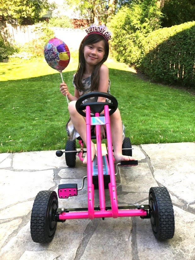 Chloe Lui-Smith, 7, in Grade 2, sits on a pink four-wheeled bicycle to celebrate her birthday. Her mother describes her as 'very social little butterfly' who misses going to school.