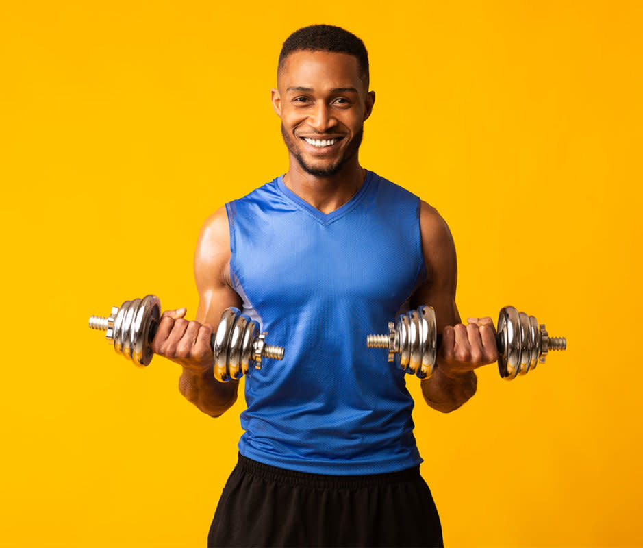 <p>Stand with feet shoulder-width apart, arms extended straight down with dumbbells at your sides, palms facing one another, and your back against a wall, to start. Perform alternating curls by rotating your forearms and flexing the elbows. Squeeze your biceps at the top, then lower back to the start position. That's 1 rep. Alternate sides.</p>