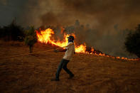 <p>A villager works to put out a forest fire in the village of Brejo Grande, near Castelo Branco, Portugal, July 25, 2017. (Rafael Marchante/Reuters) </p>