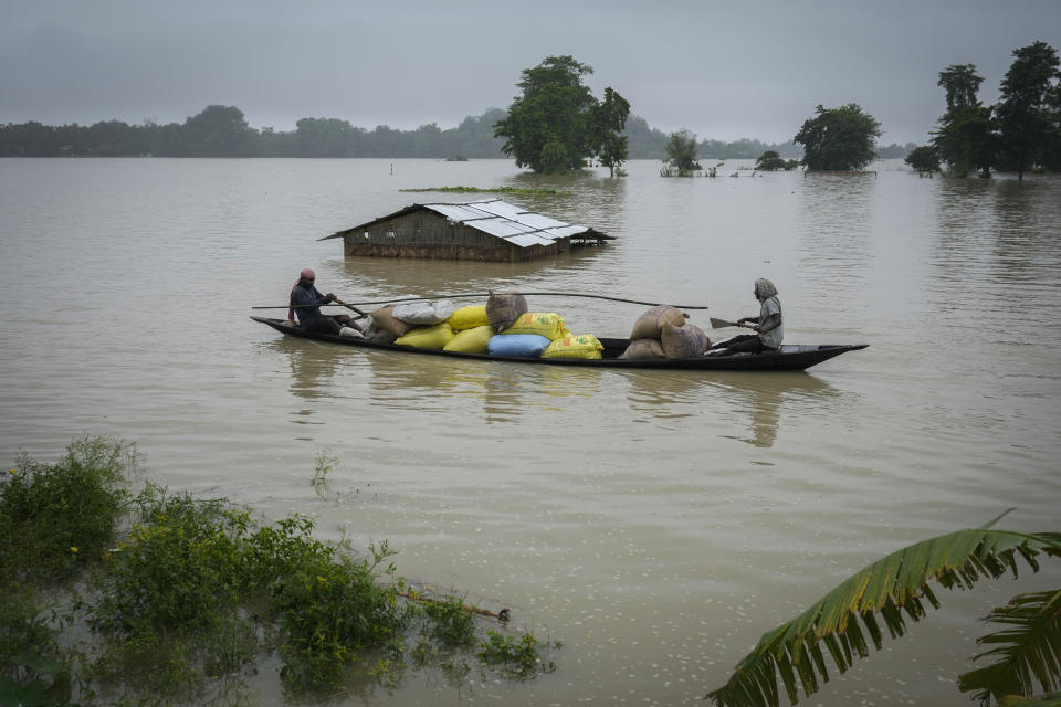 Flood affected people travel with sacks of rice in a country boat through flood waters in Mayong village in Morigaon district in the northeastern state of Assam, India, Tuesday, July 2, 2024. Floods and landslides triggered by heavy rains have killed more than a dozen people over the last two weeks in India's northeast. (AP photo/Anupam Nath)