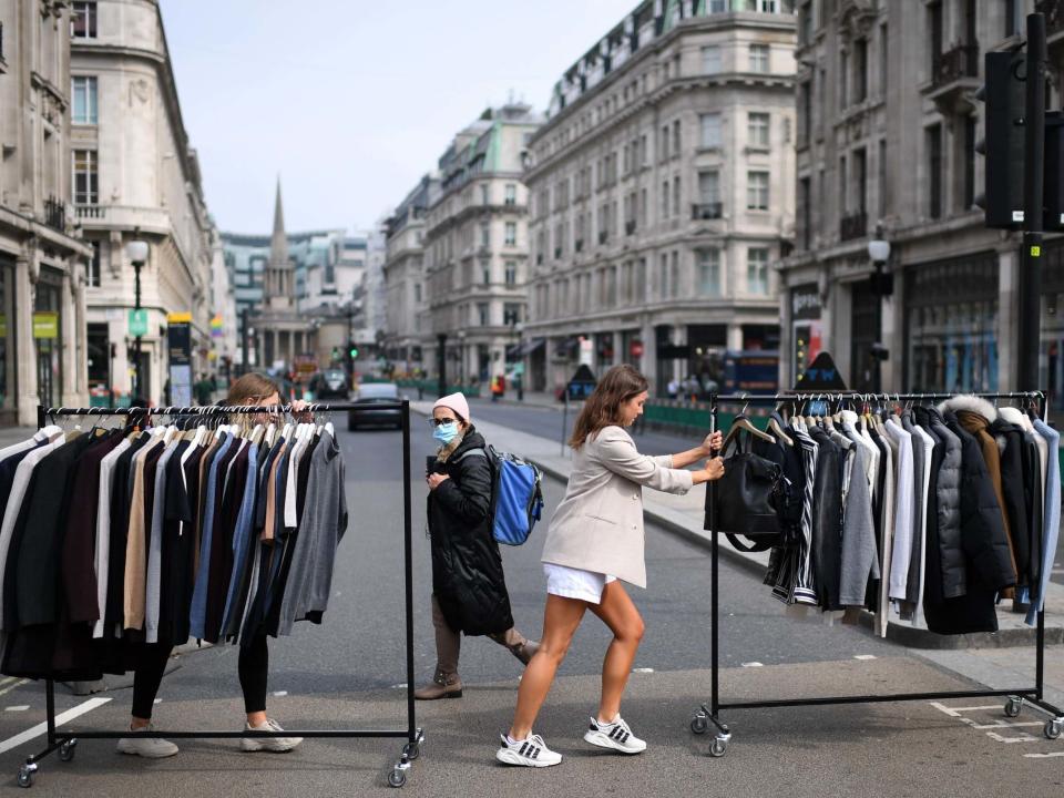 Retail workers move rails of clothes between stores on Oxford Street on 12 June: AFP/Getty