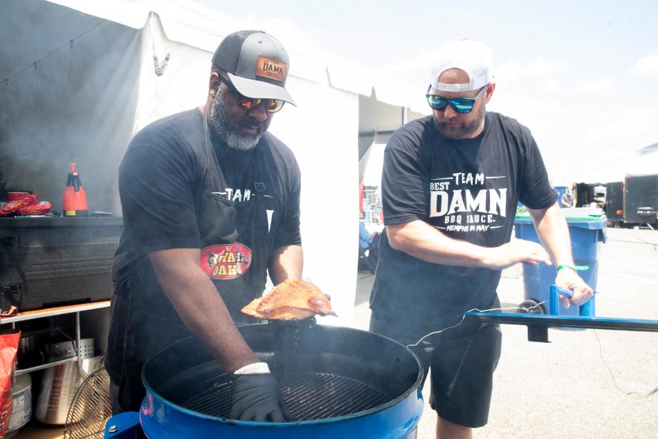 William Whitfield, head cook with Team Best Damn Barbecue, lifts out turkey being grilled for the “Turkey Smoke” competition as Eric Mendel, another cook with the team, lifts the lid off the grill at their booth during the World Championship Barbecue Cooking Contest as part of the Memphis in May International Festival in Memphis, Tenn., on Thursday, May 16, 2024.