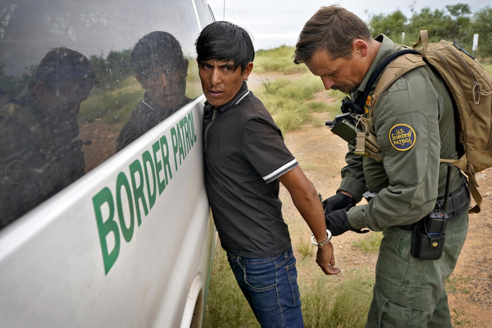 Un migrante se esposado por un agente de la Patrulla Fronteriza de EEUU tras ser detenido cruzando ilegalmente la frontera desde México cerca de Sasabe (Arizona) el 8 de septiembre del 2022. (AP Photo/Matt York)