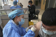 A nurse gives a shot of the Sinopharm COVID-19 vaccine developed by Beijing Institute of Biological Products Co. Ltd. to an airport worker at a health station in Nantong in east China's Jiangsu province on Jan. 29, 2021. Chinese health experts say China is lagging in its coronavirus vaccination rollout because it has the disease largely under control, but plans to inoculate 40% of its population by June. (Chinatopix via AP)