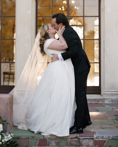 <p>Fox & Film Photography</p> Bella Grimm and Clayton Grimm kiss on their wedding day.