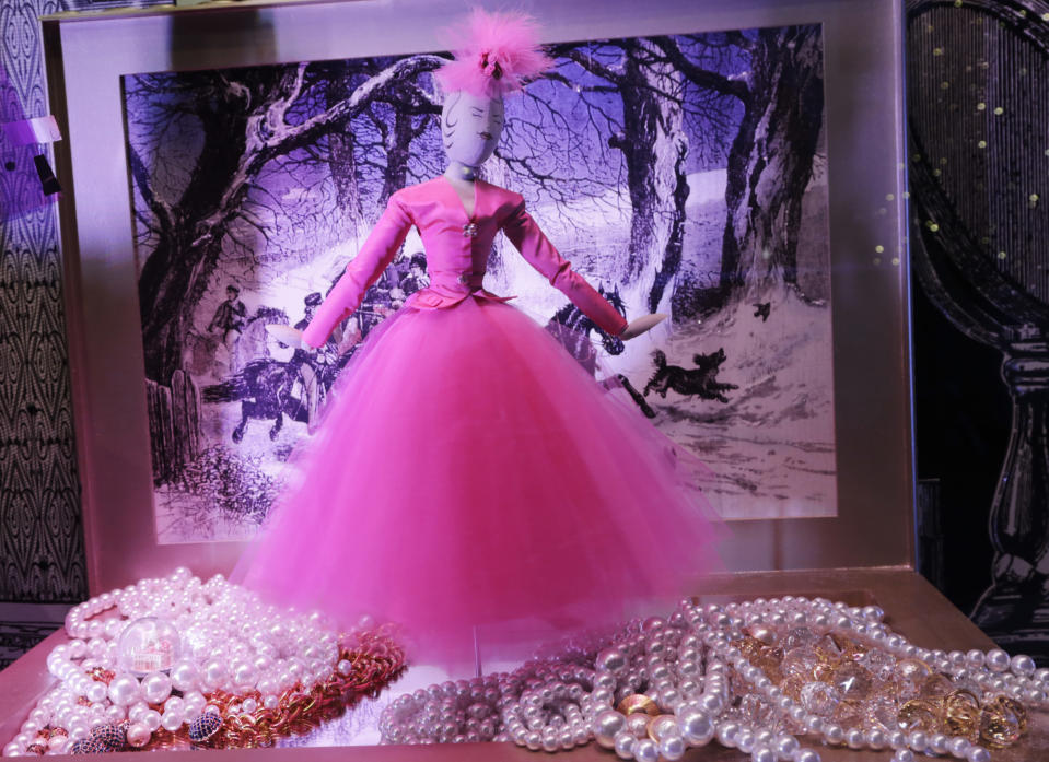 This Nov. 18, 2013 photo shows a doll in pink evening attire stands in a pile of pearls in a holiday window display at Lord & Taylor department store, in New York. Forget window shopping, some of Manhattan’s biggest and most storied retailers say their elaborate seasonal window displays are a gift to passers-by. (AP Photo/Mark Lennihan)