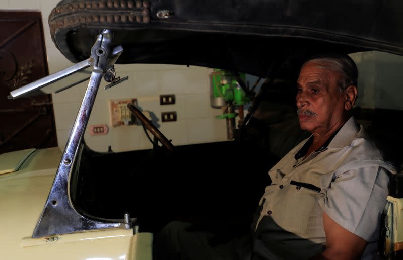 Sayed Sima, a 70-years-old Egyptian collector of vintage cars, sits in a 120-year-old American "1900 Auburn" automobile in his store, , in the Giza suburb of Abu Rawash